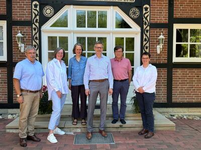 Sechs Personen stehen vor der Eingangstür eines Fachwerkhauses. Es handelt sich um den Gesellschafterkreis für die Forscherhaus gemeinnützige Bildungsgesellschaft mbH.