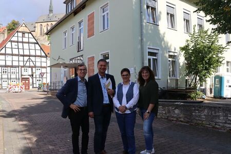 Warburgs Bürgermeister, sein Fachbereichsleiter, Kolping-Kita-Geschäftsführerin und Kitaleiterin stehen vor dem Gebäude der neuen Kolping Kita Diemelaue in Warburg.