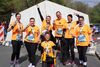 Ein Teil des Schulwerk-Firmenteams posiert beim Paderborner Osterlauf in leuchtend-orangenen Kolping-Shirts.